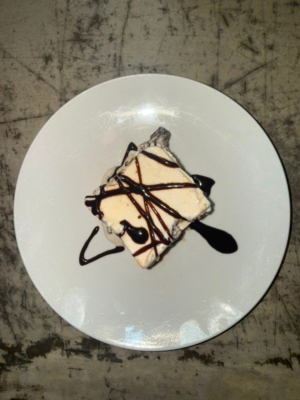 Dessert with chocolate drizzle on white plate