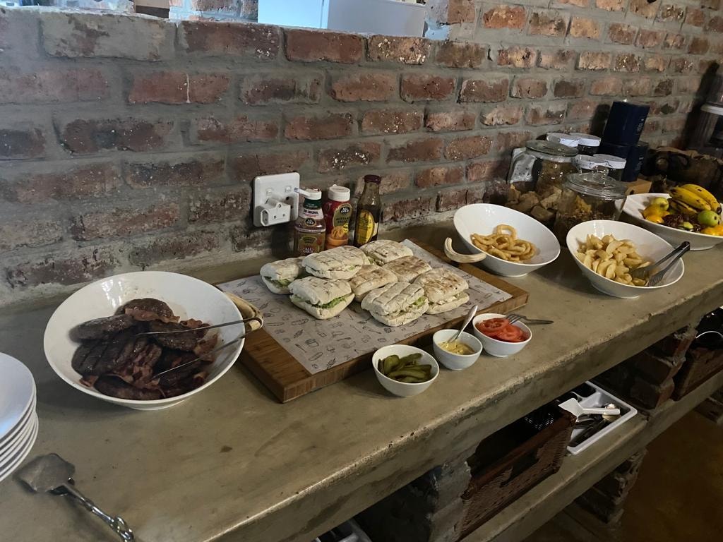 Lunch spread with sandwiches, fries and condiments on brick wall counter
