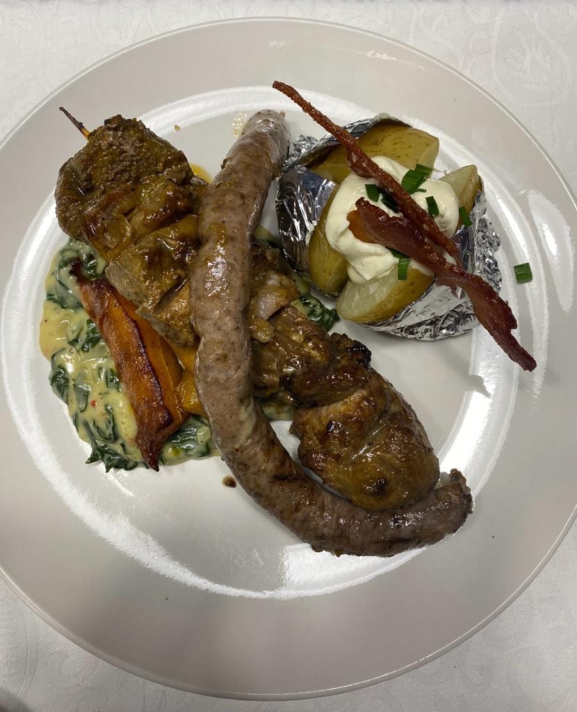 Braai plate with boerewors, ribs, baked potato and creamed spinach