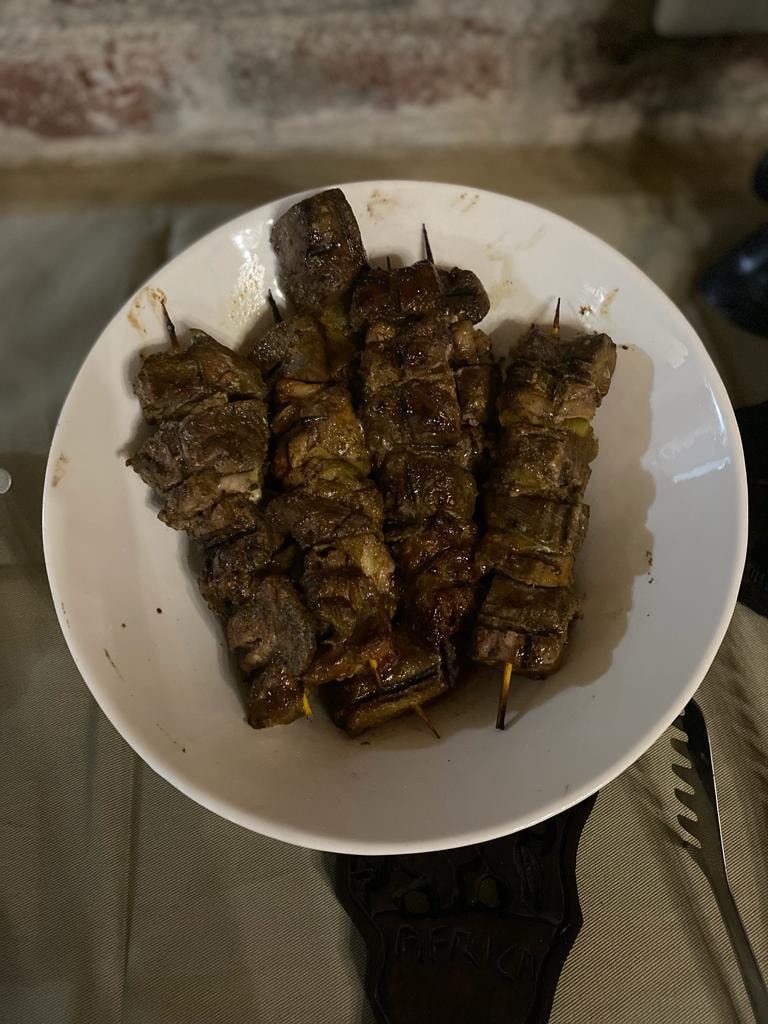 Grilled game meat skewers on white plate